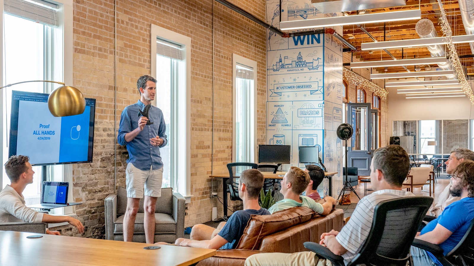A team gathered for an all-hands meeting in a loft office