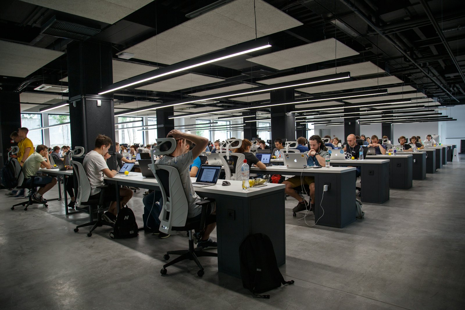 Rows of engineers at desks in a large open office