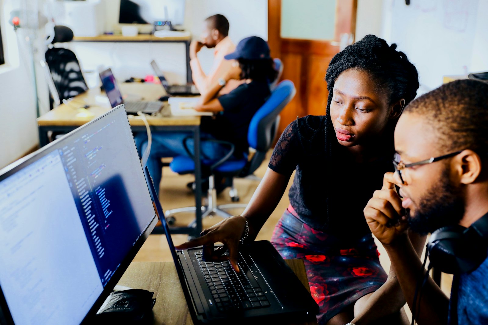 Two developers working through a problem at one screen